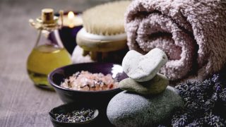 Fresh and dry lavender flowers.stones as heart shape. essential oil. pink salt. bath towel. aromatic candle on textured background.