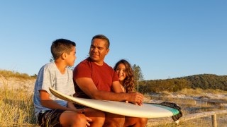 Australian Aboriginal Father and children at the beach in the early morning