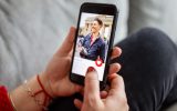 Close-up of a female using a dating app on smart phone. Woman looking at man on an online dating app on her mobile phone