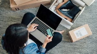 Young Woman Shopping Online While Relaxing At Home