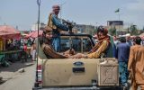 Taliban fighters on a pick-up truck move around a market area, flocked with local Afghan people at the Kote Sangi area of Kabul on August 17, 2021, after Taliban seized control of the capital following the collapse of the Afghan government.