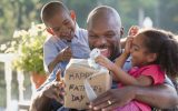 Boy and girl watching father open Father's Day gift