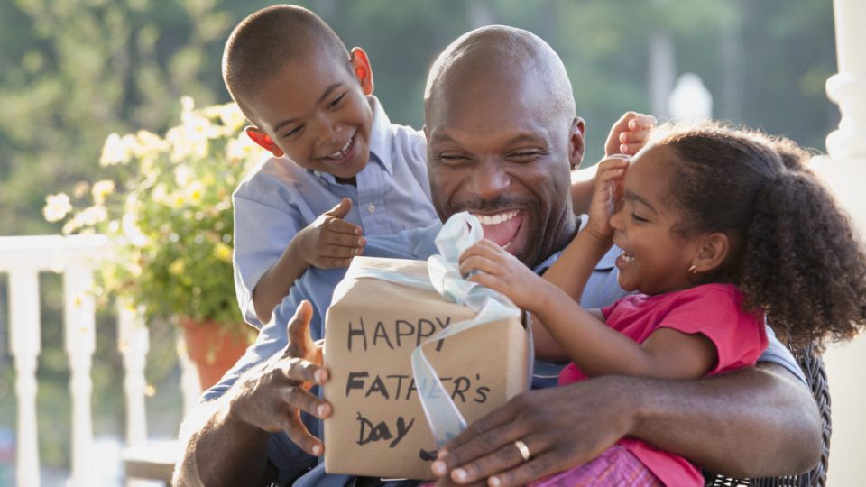 Boy and girl watching father open Father's Day gift