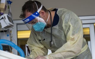 Dr. Darcy Mainville, intensivist for critical care, checking on a covid patient inside the ICU at Adventist Health Glendale