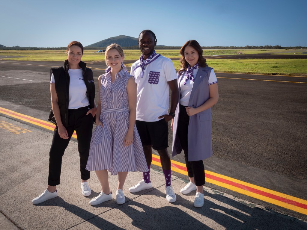 People standing on airplane tarmac smiling