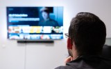 Pictured is a man watching a streaming service, like Netflix or Binge