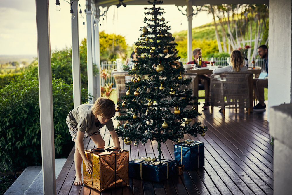 pictured is a family having Christmas lunch with a Christmas tree in the front.