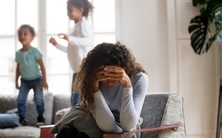 Sad mother and playful children at home