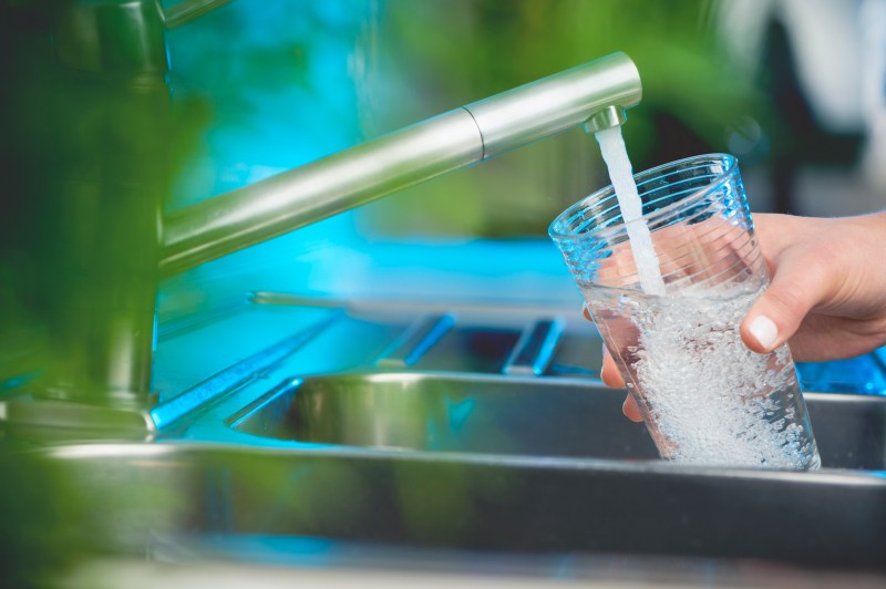 Woman filling a glass of water.