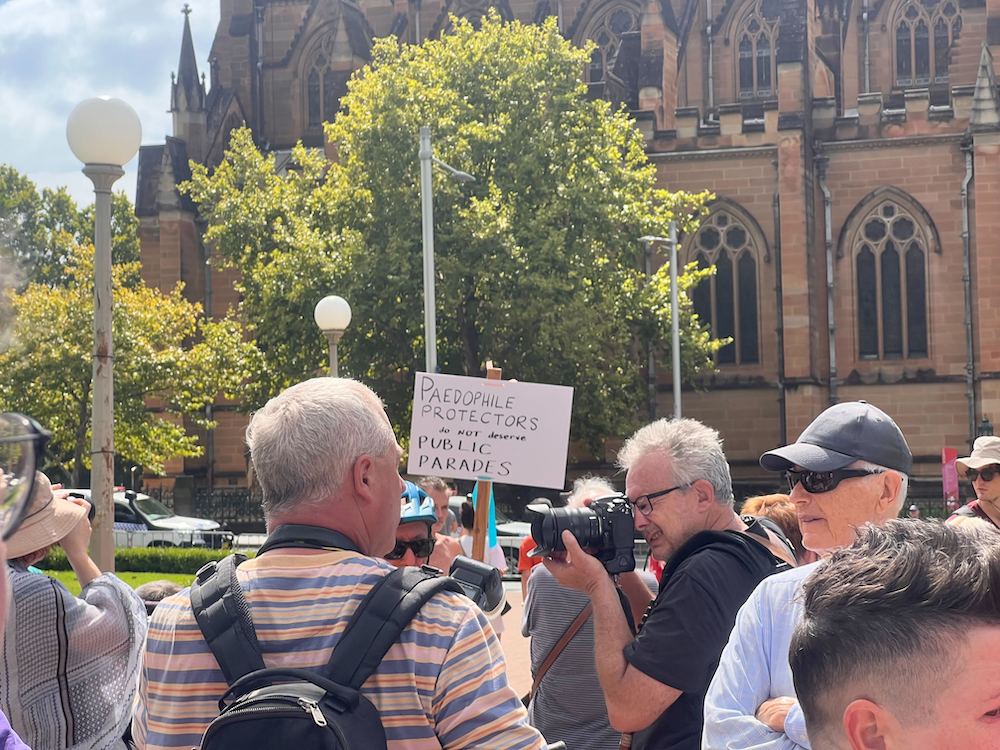 Pictured are protesters outside George Pell's funeral