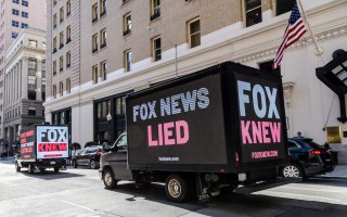 Truck billboards drive in front of the Palace Hotel calling out Fox News' election denial scheme as Fox CEO Lachlan Murdoch attends an event on March 08, 2023 in San Francisco, California
