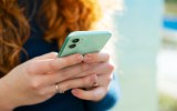 pictured is someone on their phone, to illustrate phone tracking.