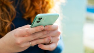 pictured is someone on their phone, to illustrate phone tracking.