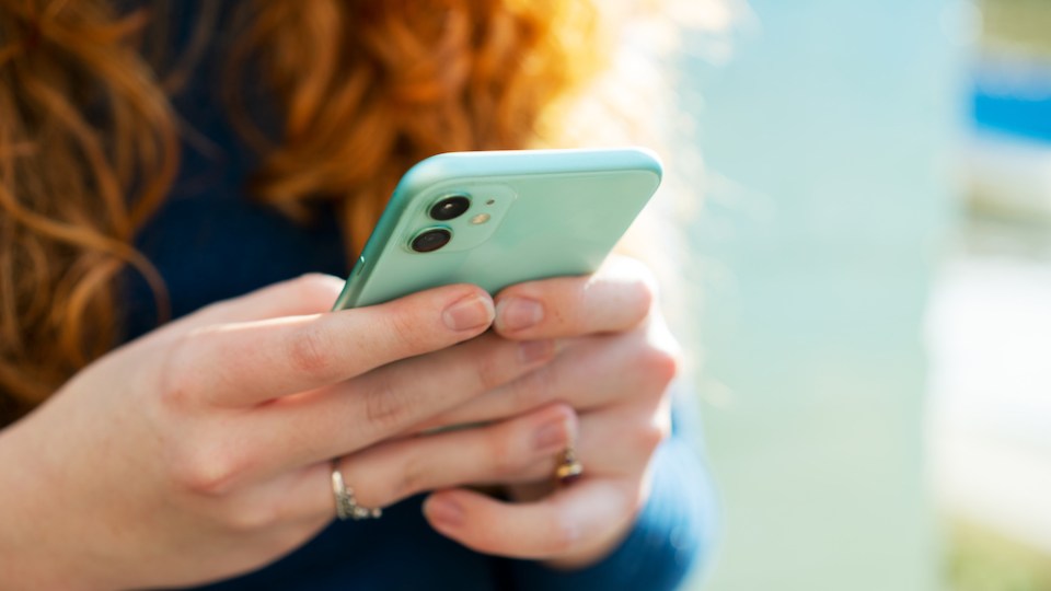 pictured is someone on their phone, to illustrate phone tracking.