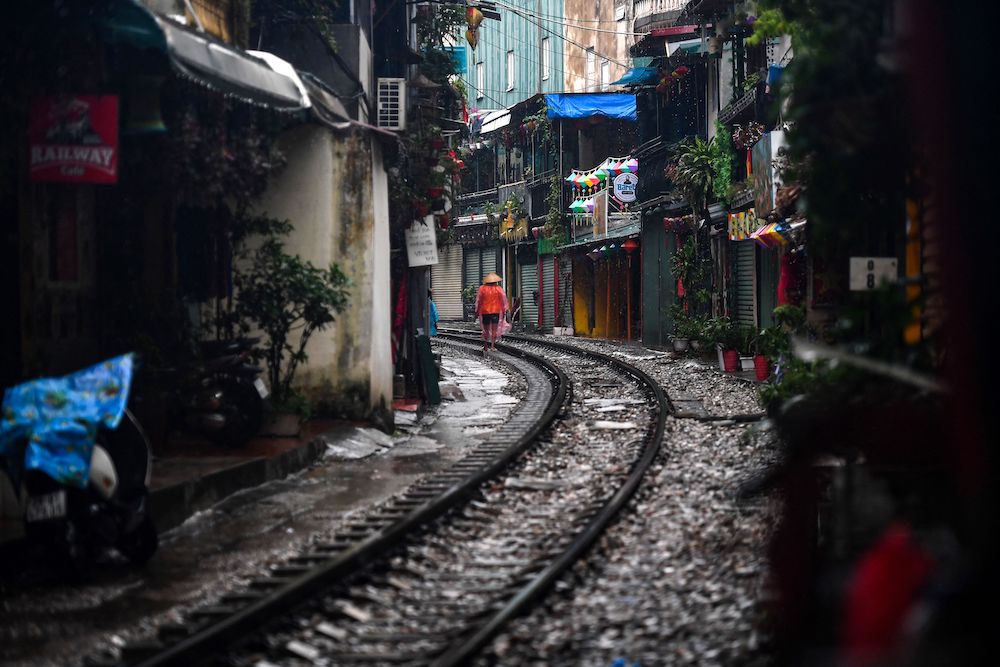 A resident walks on Hanoi's popular train street on September 16, 2022, following the announcement of its closure over safety concerns. - Snap-happy tourists and cafe owners along Hanoi's popular 'train street' spoke of their disappointment as the Instagram hotspot was blocked off due to safety concerns just weeks after reopening following a long Covid closure. 