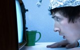 pictured is a man in a tin foil at to illustrate a conspiracy theory