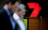 Pedestrians walk past signage of the Seven Television Network