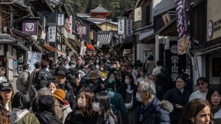 In this picture taken on March 10, 2024, people walk through a street near Kiyomizu-dera Temple in Kyoto.
