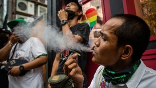 pictured is someone smoking weed in Thailand