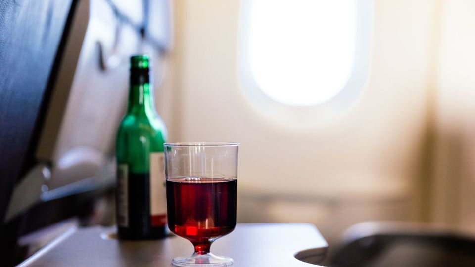 pictured is a drink of alcohol on a plane