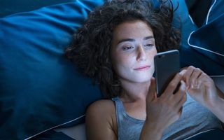 pictured is someone in bed to illustrate how phones impact sleep