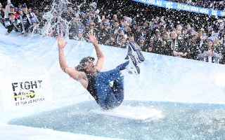 Tennis icon Pat Rafter sliding into an ice bath at the MCG, as part of FightMND's Big Freeze event