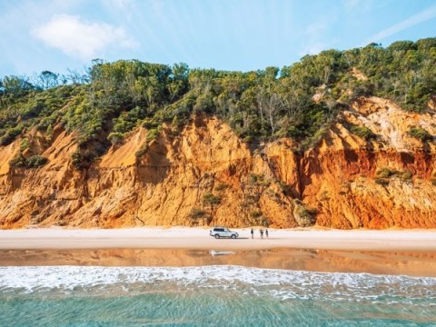Count the hues of hyper-coloured sand cliffs near Rainbow Beach. Photo: Tourism and Events Qld